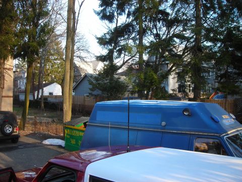 1995 Ford Bronco - A blue van is parked in a residential area with trees and houses in the background.