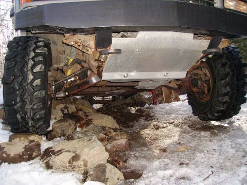 2000 Chevrolet Tahoe - Undercarriage view of an off-road vehicle navigating rocky terrain in the snow.