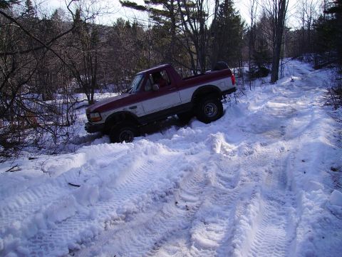 2000 Chevrolet Tahoe - Pickup truck navigates a snow-covered trail with deep tire tracks.