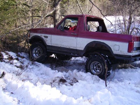2000 Chevrolet Tahoe - A red and white Ford Bronco navigates a snowy, wooded area.