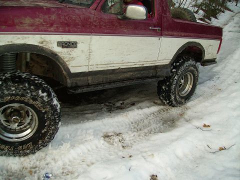 2000 Chevrolet Tahoe - A two-tone Ford Bronco is shown driving through a snowy, wooded area.