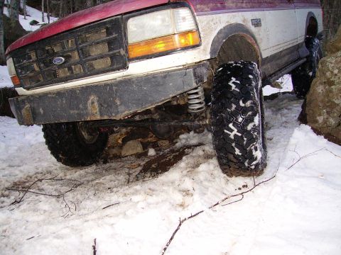 2000 Chevrolet Tahoe - Ford Bronco navigating snowy terrain with large off-road tires.
