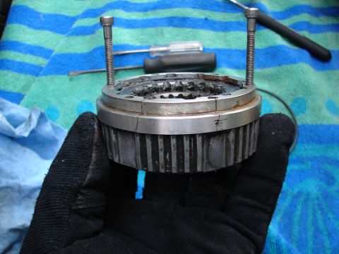 1996 Ford Bronco - A gloved hand holds a disassembled manual locking hub assembly with tools in the background.