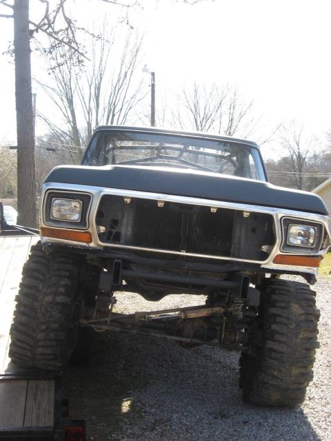 1979 Ford Bronco - Front view of a lifted 1979 Ford Bronco with oversized tires and a missing grille.