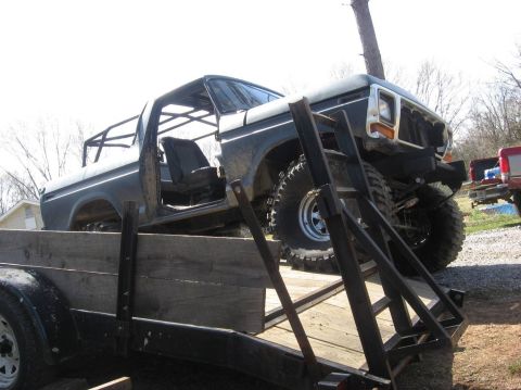 1979 Ford Bronco - This modified Ford Bronco is being transported on a trailer, showing its off-road tires and interior roll cage.