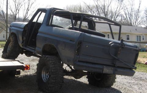 1979 Ford Bronco - This lifted 1979 Ford Bronco features a prominent roll cage and large off-road tires, seen here being loaded onto a trailer.