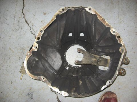 1979 Ford Bronco - Clutch bell housing with internal fork mechanism shown on a concrete surface.