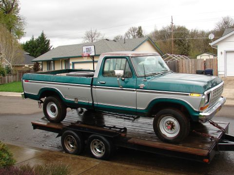 1996 Ford Bronco - This two-tone green and silver Ford F-Series pickup truck is loaded onto a trailer.