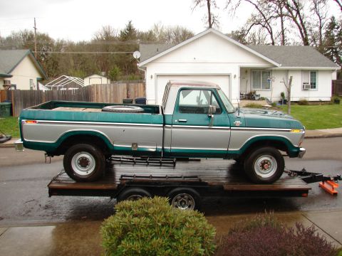 1996 Ford Bronco - A two-tone green and silver Ford F-Series pickup truck is loaded onto a flatbed trailer.