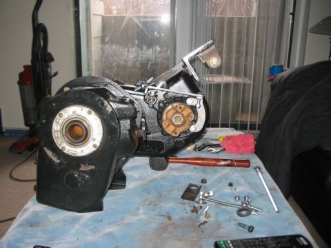 1991 Ford Bronco - A black transfer case is disassembled on a blue cloth, with tools and various small parts laid out nearby.