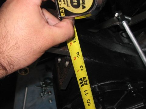1991 Ford Bronco - A close-up shot shows a hand using a tape measure to gauge the size of a vehicle's mechanical part.