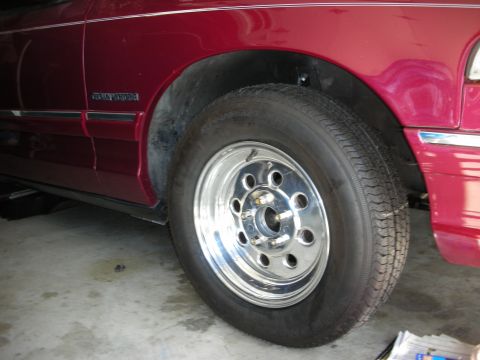 1992 Ford Crown Victoria - Close-up of a red 1992 Ford Crown Victoria's front wheel and fender.