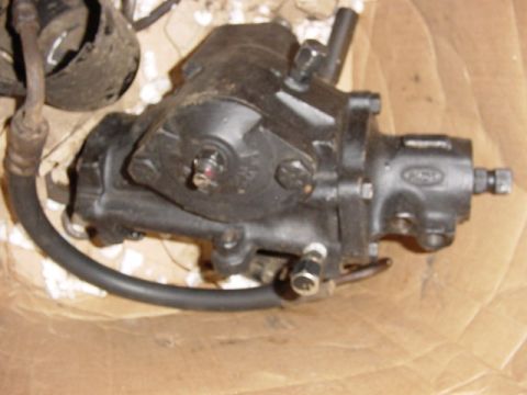 1992 Ford Bronco - A black recirculating-ball steering gearbox, likely from a Ford, with a Ford oval logo cast into the housing and an attached power steering…