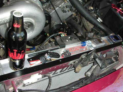 1992 Ford Crown Victoria - A beer bottle and keys rest on a car's radiator in the engine bay.