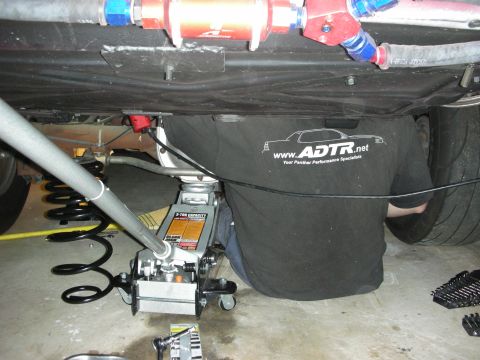 1992 Ford Crown Victoria - A person works on the fuel system underneath a vehicle, with the ADTR.net logo visible on their shirt.