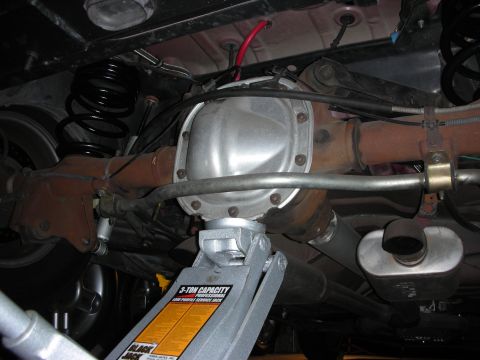 1992 Ford Crown Victoria - Car's rear axle and suspension components are visible, supported by a floor jack.