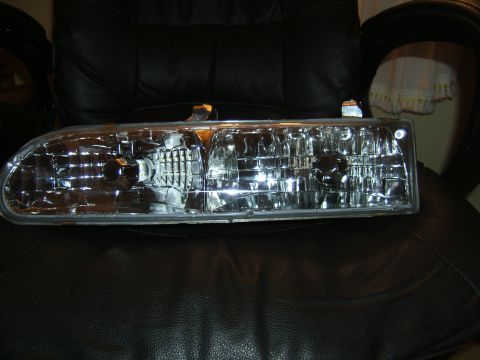 1998 Ford Taurus - Headlight assembly shown on a dark background.