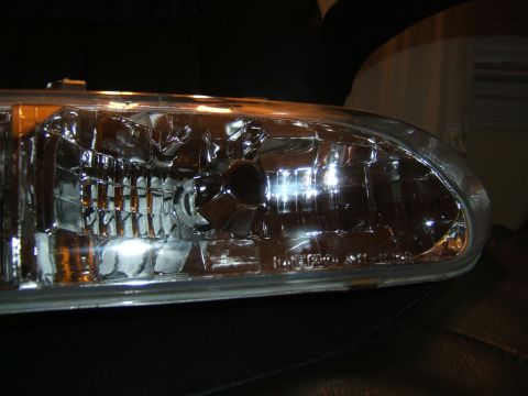 1998 Ford Taurus - This is a close-up view of a vehicle's headlight assembly, focusing on the intricate details of the lens and reflector.