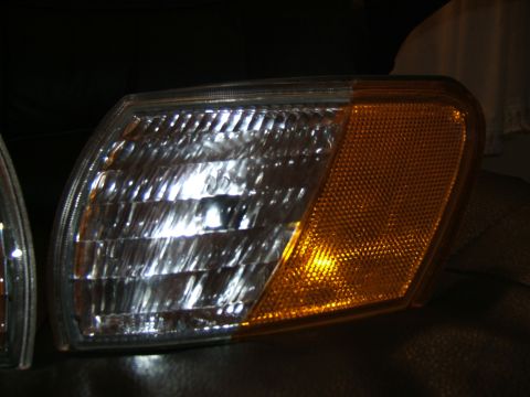 1998 Ford Taurus - A close-up view of a vehicle's clear and amber corner light assembly.