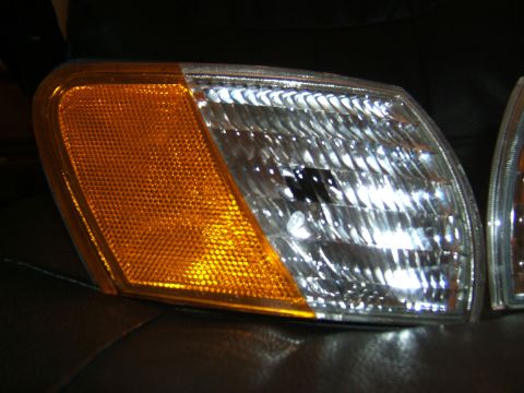 1998 Ford Taurus - A car headlight assembly with an amber turn signal and a clear multi-reflector lens is shown.