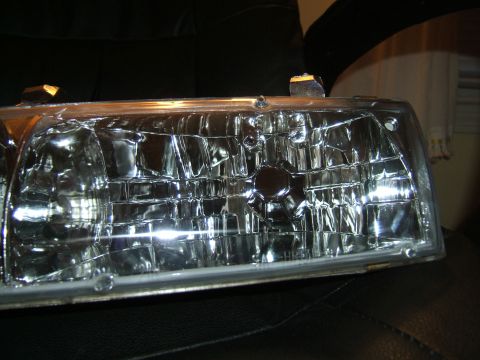 1998 Ford Taurus - This is a close-up view of a vehicle headlight assembly, likely a replacement part.