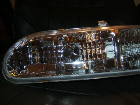 1998 Ford Taurus - Headlight assembly with intricate reflector pattern, likely for a car part.