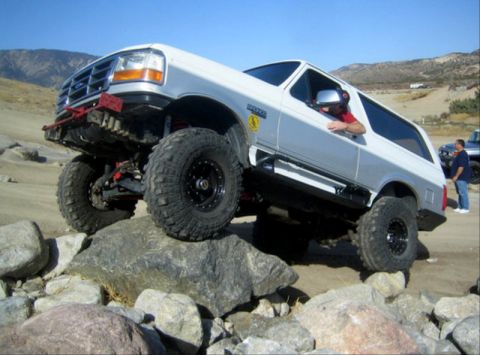 1996 Ford Bronco - This modified 1996 Ford Bronco navigates a rocky trail with its driver visible through the window.