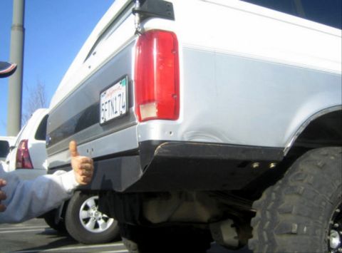 1996 Ford Bronco - A person gives a thumbs up next to the rear of a silver and gray Ford Bronco.