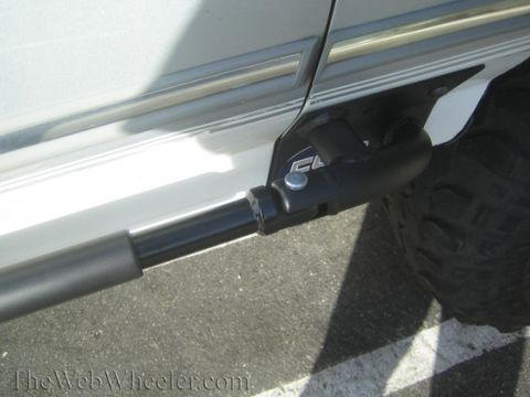1996 Ford Bronco - Close-up view of a side step and tire on a white vehicle, with a partial view of the body trim.