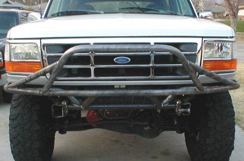 1996 Ford Bronco - Head-on view of a lifted white Ford truck fitted with a bare-steel tube prerunner bumper with a raised center hoop and welded shackle mount…
