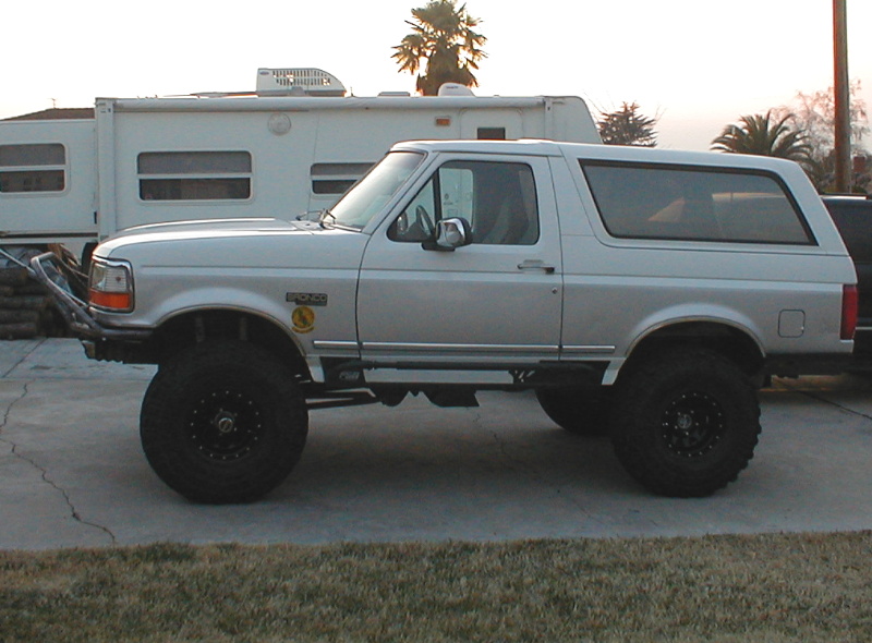 1996 Ford Bronco side profile, lifted with large off-road tires and custom front bumper