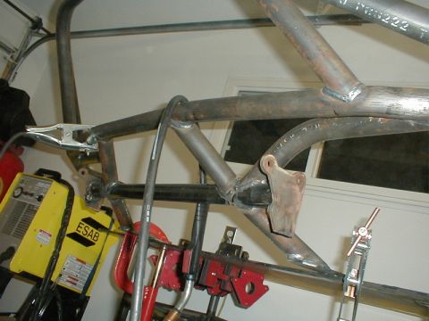 1996 Ford Bronco - Custom roll cage tubing is being welded and assembled in a garage setting with welding equipment visible.