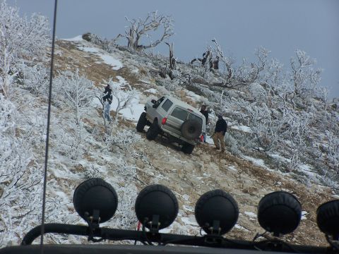 1996 Ford Bronco - An off-road vehicle navigates a challenging, icy incline amidst a winter landscape.