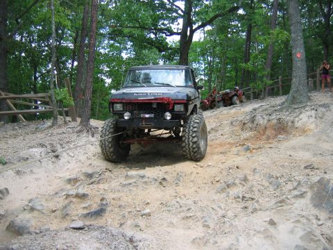 1992 Ford Mustang - Modified truck navigating a challenging rocky off-road course with other vehicles present.