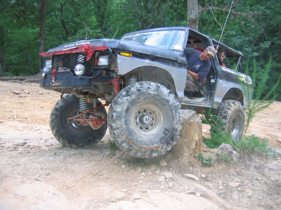 Lifted black off-road truck with large tires on a dirt trail