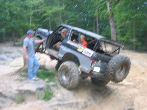 1992 Ford Mustang - A modified 1992 Ford Mustang is seen off-roading on a dirt path with trees in the background.