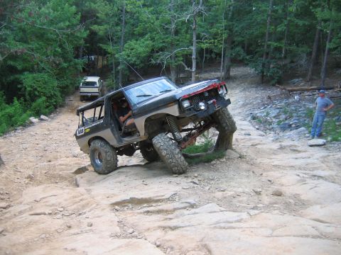 1992 Ford Mustang - This modified SUV is navigating a difficult rocky terrain on an off-road trail.