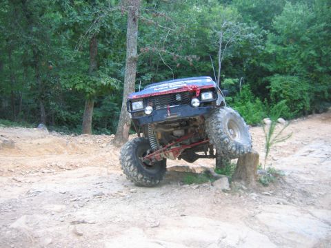 1992 Ford Mustang - An off-road vehicle navigates a challenging rocky terrain with its tires elevated.