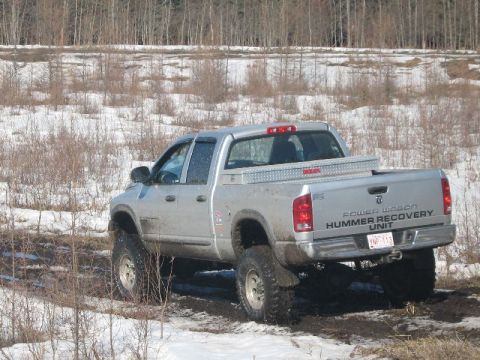1995 Ford Bronco - Modified Dodge Ram pickup truck with "POWER WAGON HUMMER RECOVERY UNIT" graphics on the tailgate.