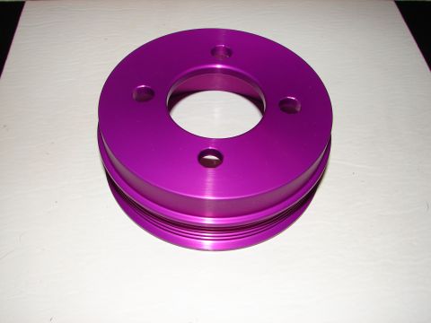 1992 Ford Taurus - A purple aluminum pulley with a grooved outer edge sits on a white surface.