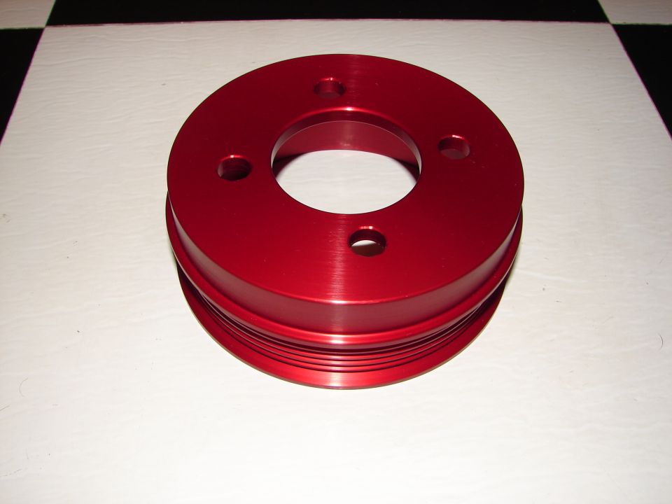 Red anodized aluminum pulley with three bolt holes and a grooved outer edge