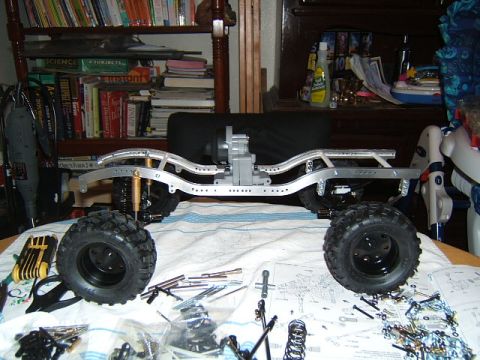 1988 Ford Bronco - RC crawler chassis assembly in progress, with parts and instructions laid out on a table.