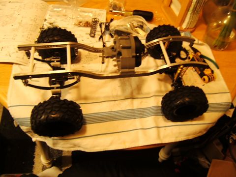 1988 Ford Bronco - RC crawler chassis assembly on a striped towel with tools and parts nearby.