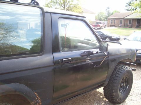 1989 Ford Bronco II - Side profile of a black 1989 Ford Bronco II, its door, fender, and off-road tires.