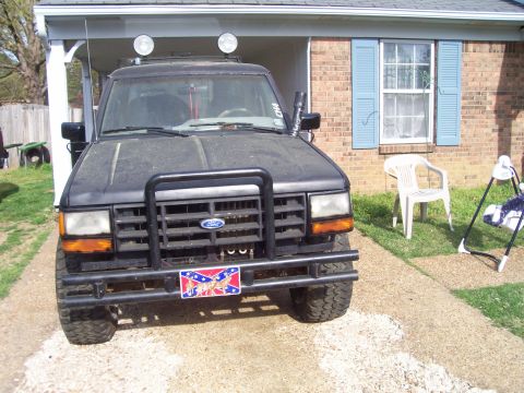 1989 Ford Bronco II - A 1989 Ford Bronco II is parked in front of a brick house with blue shutters.