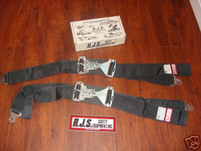 1978 Ford Bronco - A pair of RJS safety seat belts are laid out on a wooden surface next to their original box.