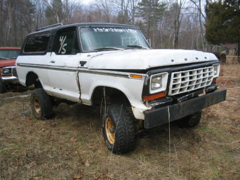 1979 Ford Bronco - This white Ford Bronco, likely a 1978 model, sits in a grassy lot with another vehicle partially visible.
