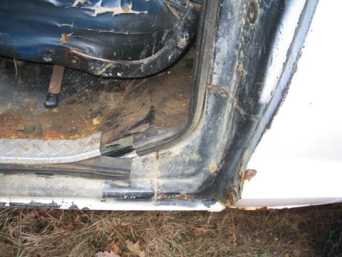 1979 Ford Bronco - Close-up view of the interior door frame and a torn seat, showing signs of wear and rust.