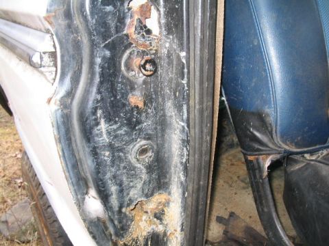 1979 Ford Bronco - The interior shows significant rust damage around the door frame and a blue vinyl seat.