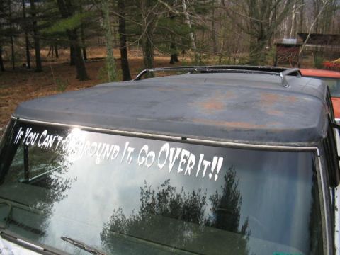 1979 Ford Bronco - Top view of a vehicle's roof and windshield, with a reflective sticker and another vehicle in the background.